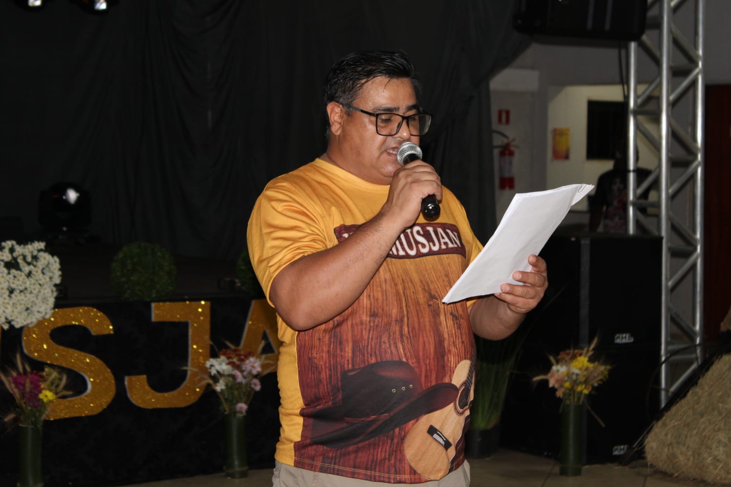 Nelson Silva usando microfone em evento